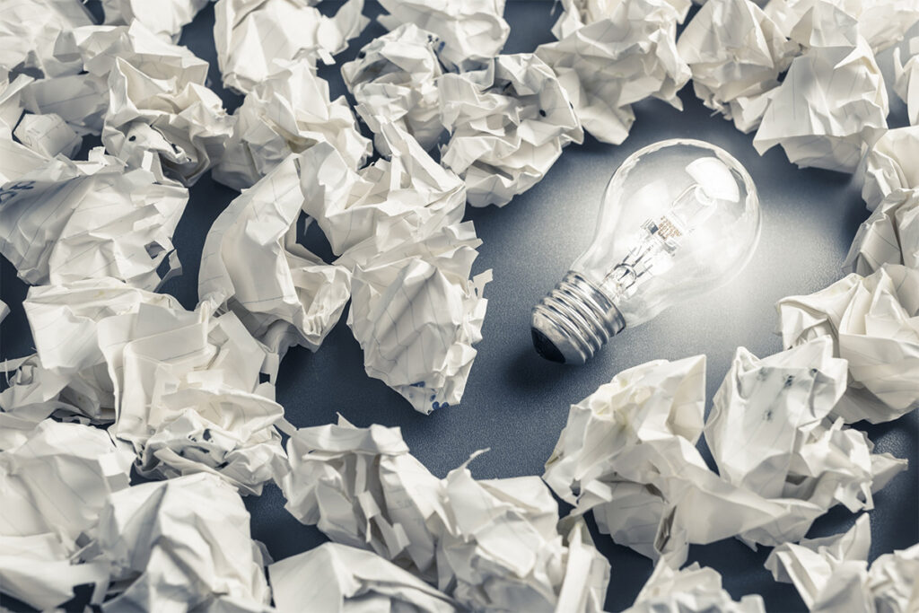 light bulb surrounded by crumpled paper